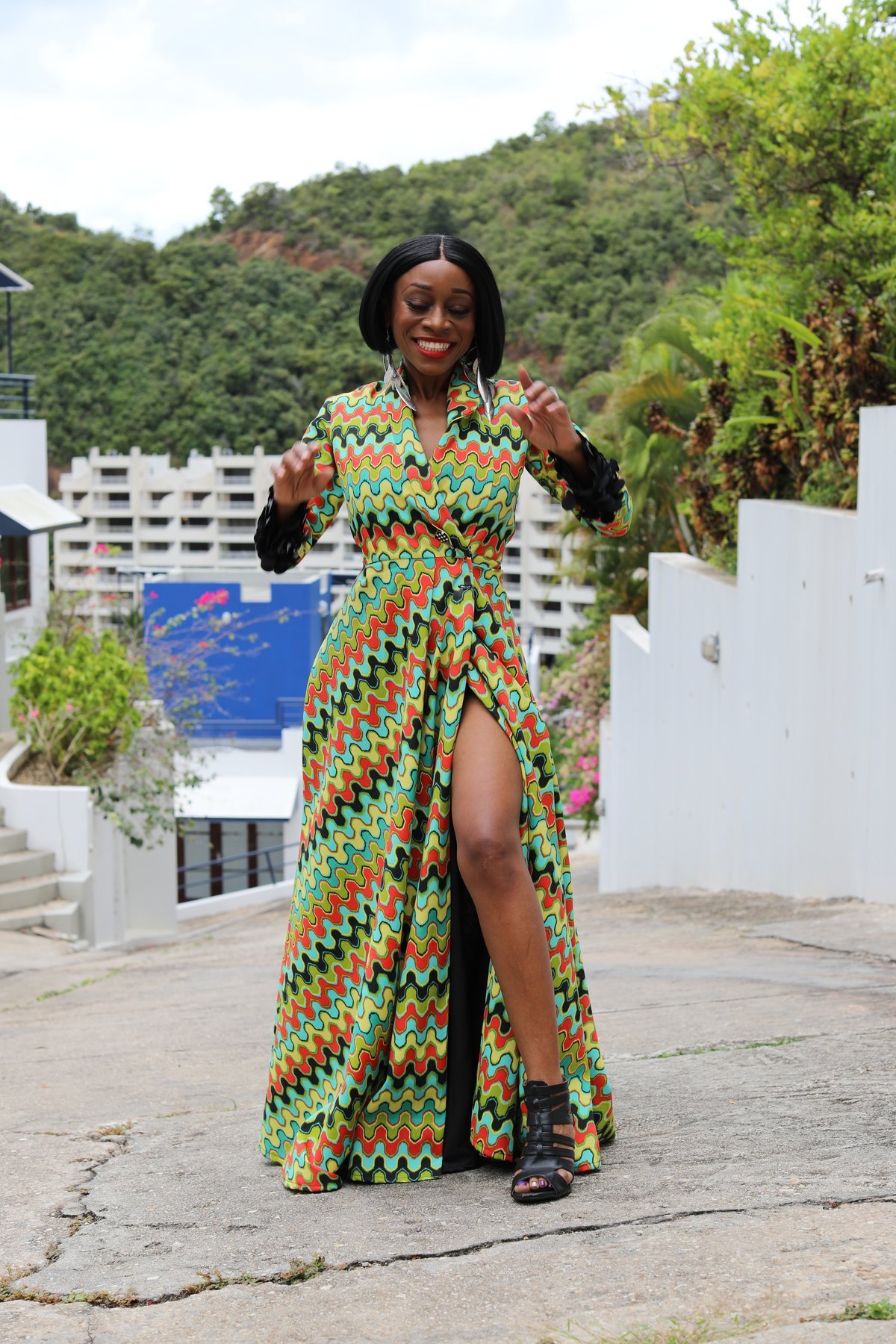 Portrait of designer Stacey Weekes-Benjamin laughing outdoors in a colourful printed gown